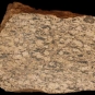 Colour image of brown rock mottled with black and yellow spots