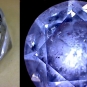 Double colour image of round, clear gemstone with blue reflection