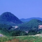 Colour photograph of highway and two large mountains in background