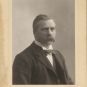 Black and white photograph of man in a suit with a mustache