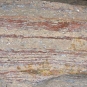 Colour image of gray rock with horizontal red striping