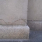 Colour photograph of slab of gray rock at base of building column