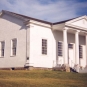 Colour photograph of large white building with four columns