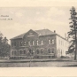 Carte postale noir et blanc d’un grand édifice carré en pierre aux dormants de fenêtres arrondis