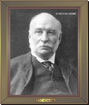 Image noir et blanc d'un homme chauve en complet portant moustache et favoris blancs