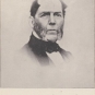 Black and white photograph of a balding man with whiskers