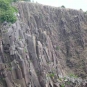 Colour photograph of a gray rock cliff