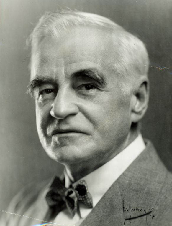 Black and white photograph of man with gray hair in a suit and a bowtie