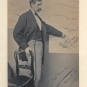 Black and white photograph of man standing and pointing at a picture on the wall